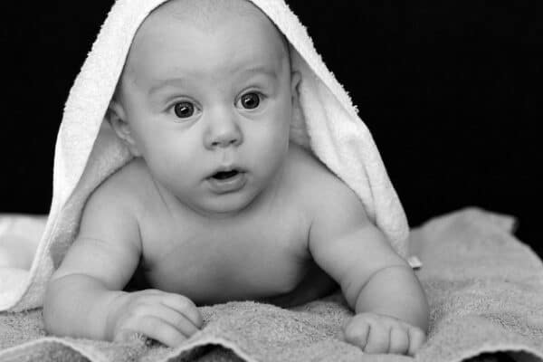 Photographie d'un bébé surpris pour illuster la conférence sur la confusion entre le sein et la tétine.